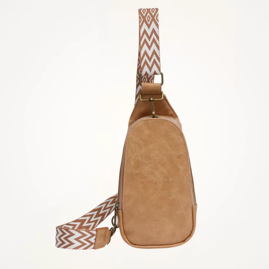 "Saddle-tan vegan leather crossbody bag with adjustable strap, perfect for a stylish and eco-friendly look."