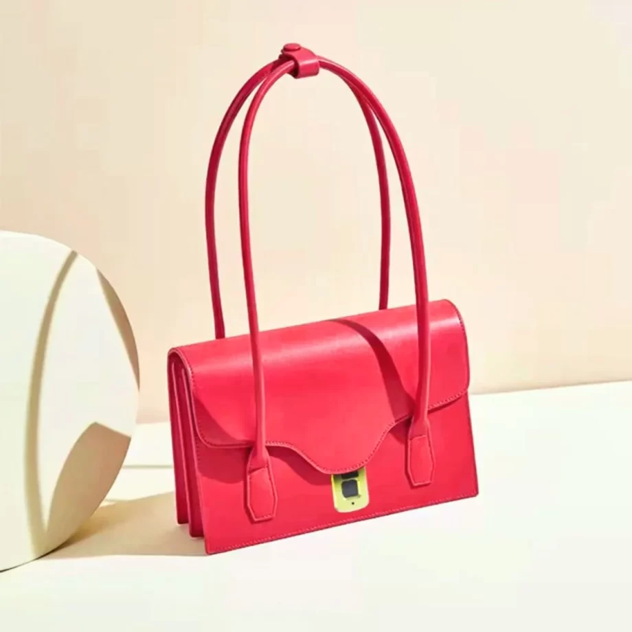 Scarlet Elegance Handbag: A vibrant red handbag featuring a sleek design, gold-toned clasp, and a patterned fabric handle, embodying elegance and style.